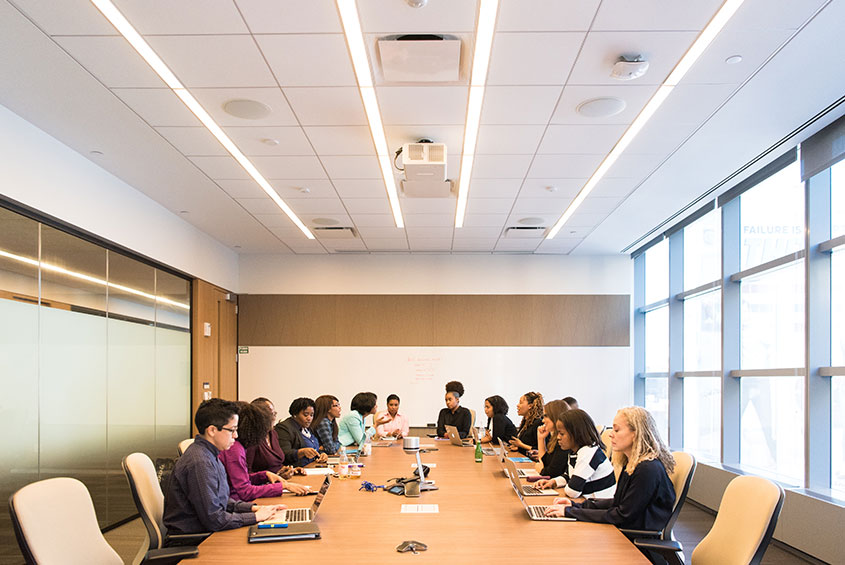 work conference room full with people seated during a meeting